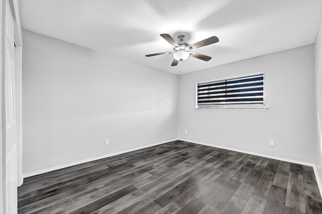 empty room with a ceiling fan, dark wood finished floors, a textured ceiling, and baseboards