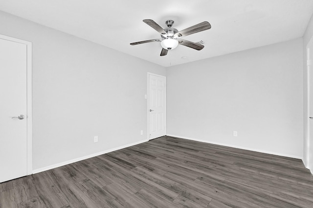 spare room with wood finished floors, a ceiling fan, and baseboards