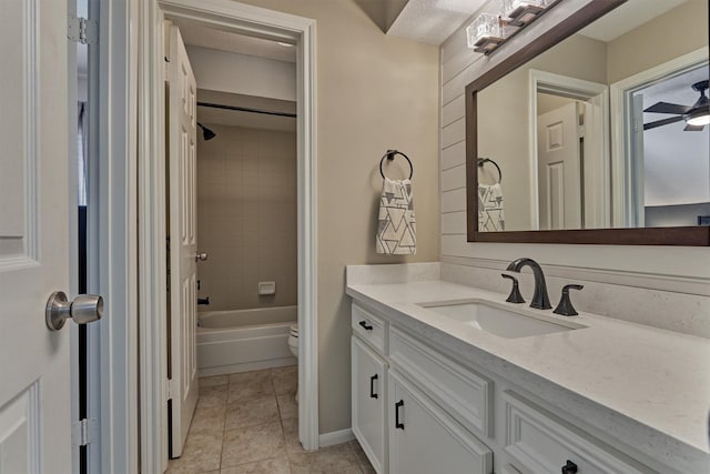 full bath with toilet, a ceiling fan, vanity,  shower combination, and tile patterned flooring