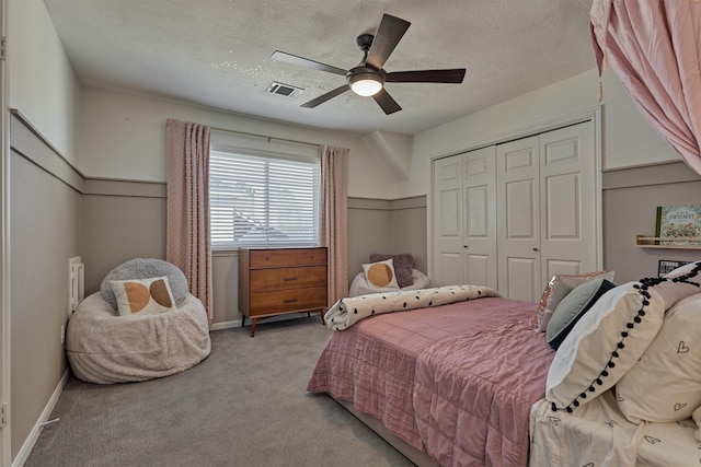 carpeted bedroom with baseboards, visible vents, a ceiling fan, a textured ceiling, and a closet