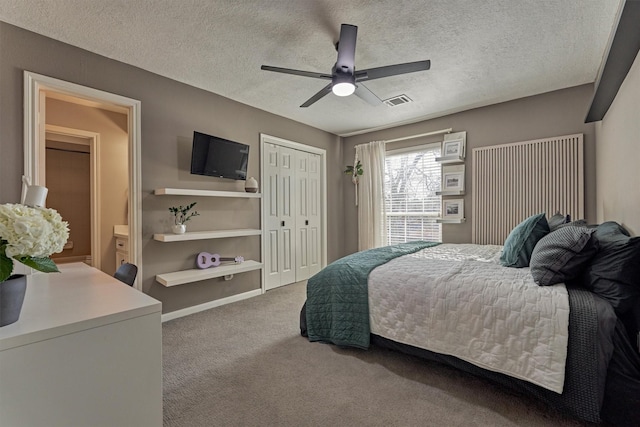 carpeted bedroom featuring a textured ceiling, a closet, and visible vents