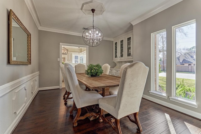 dining space with ornamental molding, a chandelier, dark wood finished floors, and baseboards