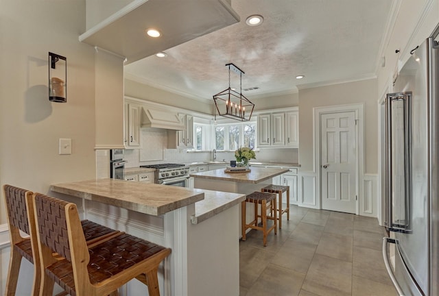 kitchen featuring a peninsula, a breakfast bar, light countertops, custom exhaust hood, and high end appliances