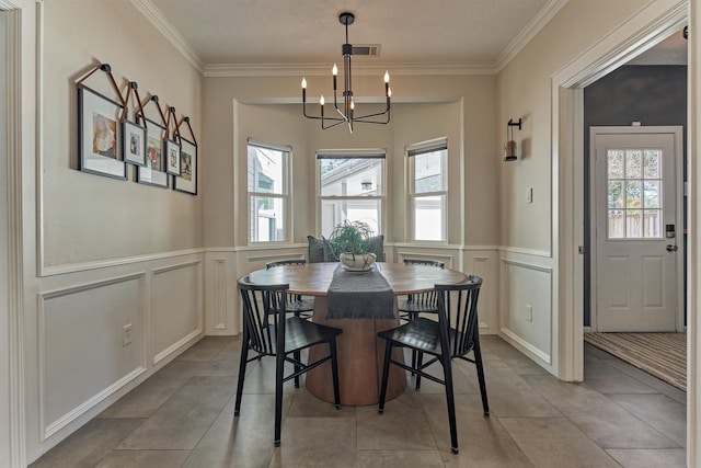 dining area with ornamental molding, a wealth of natural light, and a notable chandelier