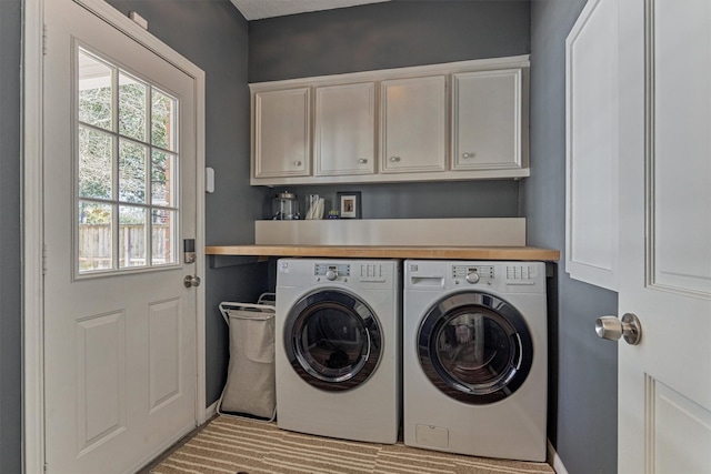 clothes washing area featuring cabinet space and independent washer and dryer