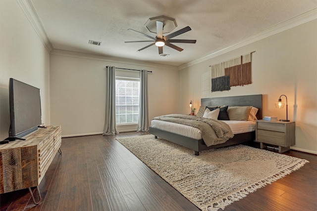 bedroom featuring dark wood finished floors, visible vents, and crown molding