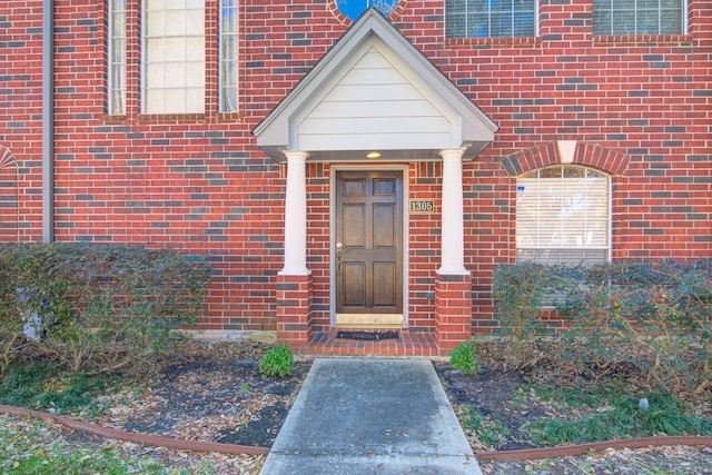 property entrance featuring brick siding