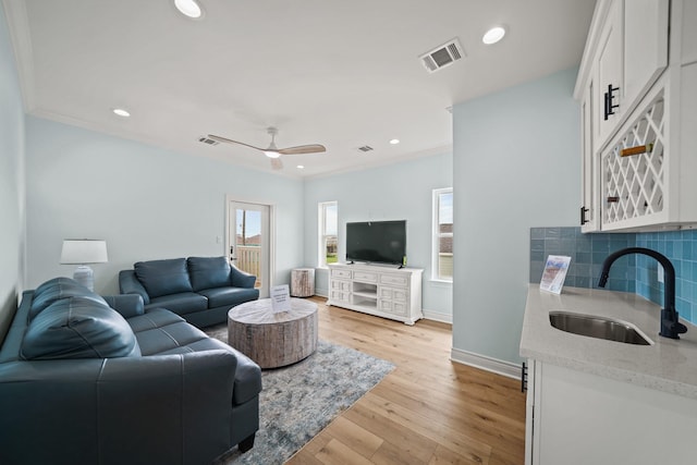 4411 Ranger Dr, Crystal Beach, TX 77650 - living room with plenty of natural light, baseboards, crown molding, light wood-style floors, and a ceiling fan