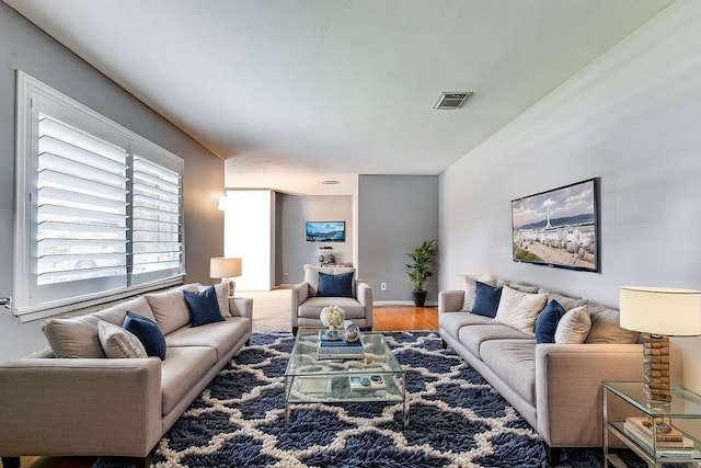 living room featuring wood finished floors, visible vents, and baseboards