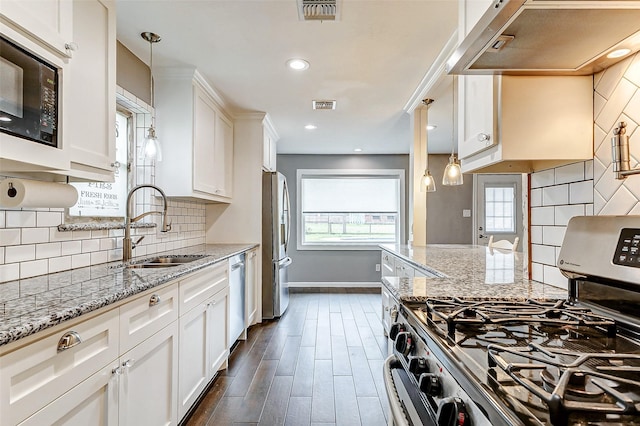 kitchen with appliances with stainless steel finishes, visible vents, a sink, and white cabinetry