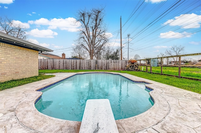 view of swimming pool featuring a fenced backyard, a fenced in pool, a diving board, and a lawn