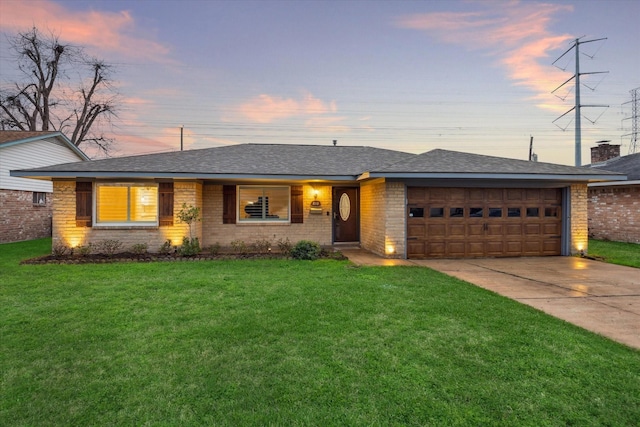 single story home with an attached garage, concrete driveway, roof with shingles, and a front yard