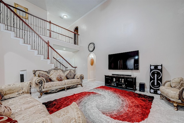 living area with carpet floors, a high ceiling, baseboards, stairs, and ornamental molding