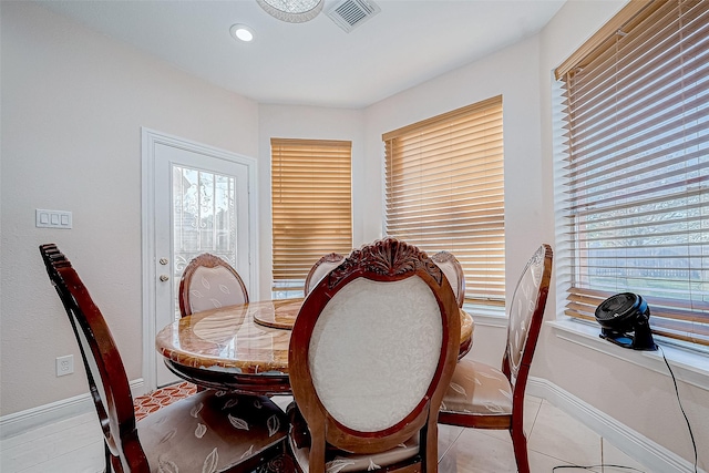 dining room with light tile patterned flooring, plenty of natural light, visible vents, and baseboards