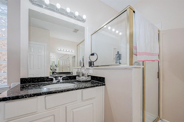 bathroom with a stall shower, visible vents, and vanity