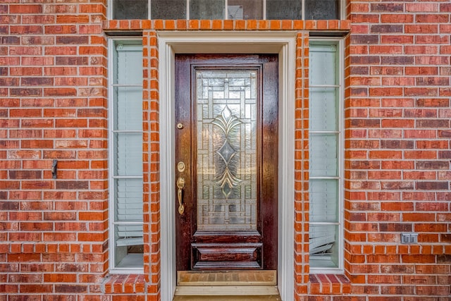 property entrance featuring brick siding