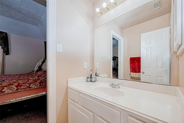 ensuite bathroom with visible vents, connected bathroom, and vanity