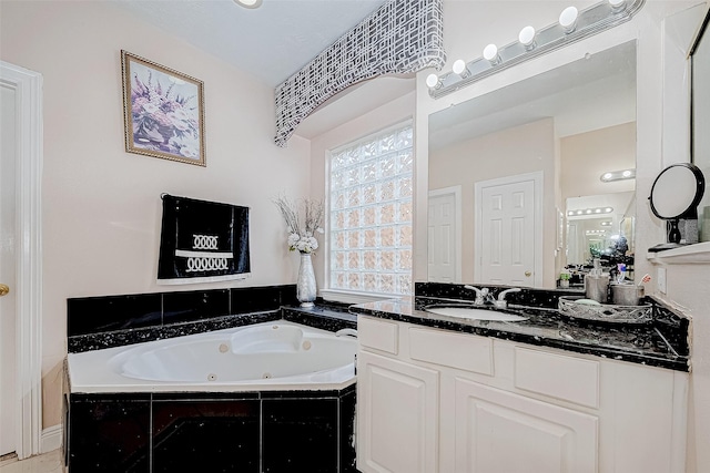 bathroom with a tub with jets and vanity