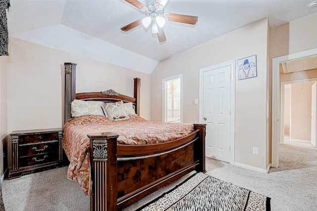 bedroom featuring light carpet, baseboards, vaulted ceiling, ensuite bath, and attic access