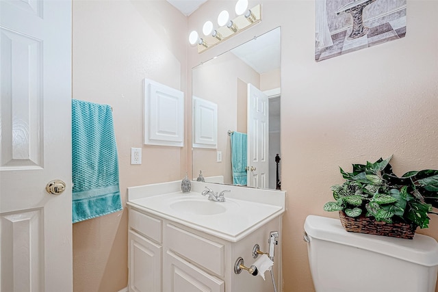 half bathroom with toilet and vanity