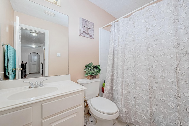 bathroom with toilet, curtained shower, and vanity