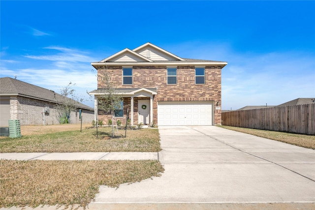 traditional home with brick siding, an attached garage, a front yard, fence, and driveway