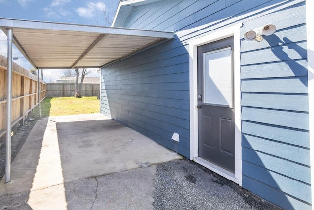 property entrance featuring a carport and fence