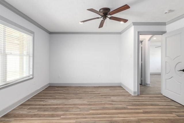 unfurnished room featuring ornamental molding, baseboards, and wood finished floors