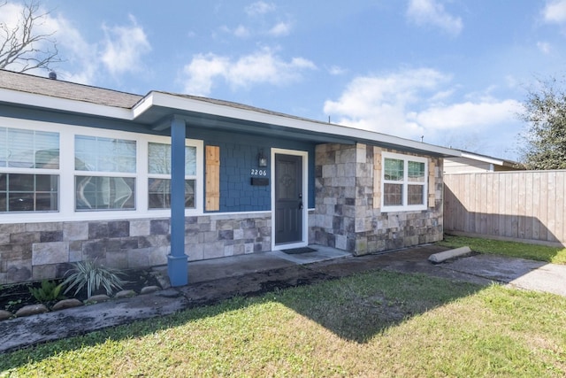 view of front of house with a front yard and fence