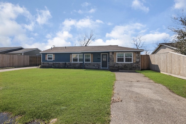 view of front of property with stone siding, a front lawn, and fence