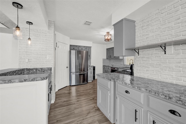 kitchen featuring freestanding refrigerator, open shelves, light wood-style floors, dishwasher, and gray cabinetry