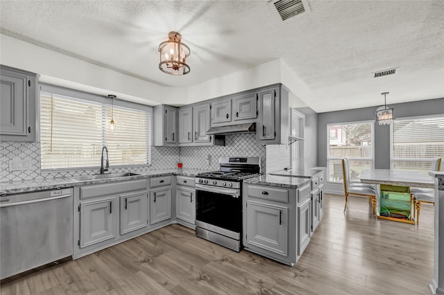 kitchen with stainless steel appliances, gray cabinets, and a sink