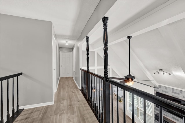 hall featuring baseboards, an upstairs landing, and wood finished floors