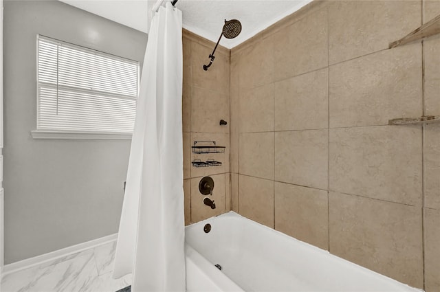 bathroom featuring baseboards, shower / bath combo, and marble finish floor