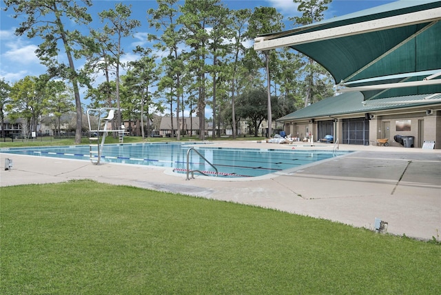 community pool with a lawn and a patio area