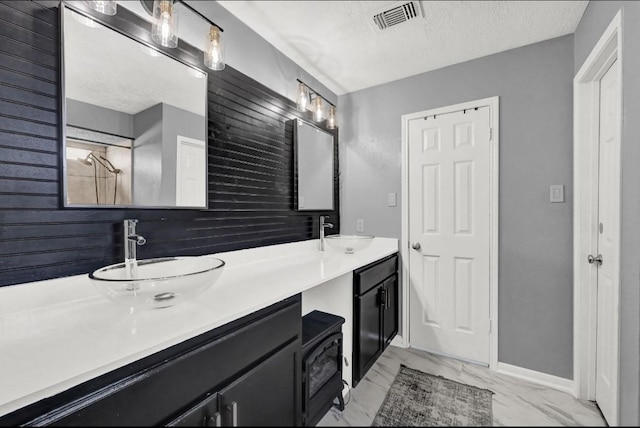 bathroom with a sink, marble finish floor, double vanity, and visible vents