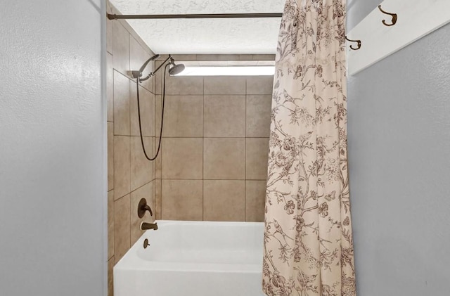 bathroom featuring a textured wall and shower / bath combo with shower curtain