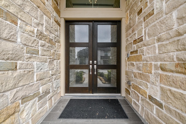 entrance to property featuring stone siding and french doors