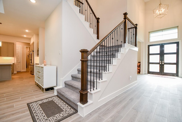 entryway with french doors, wood finish floors, stairway, and baseboards