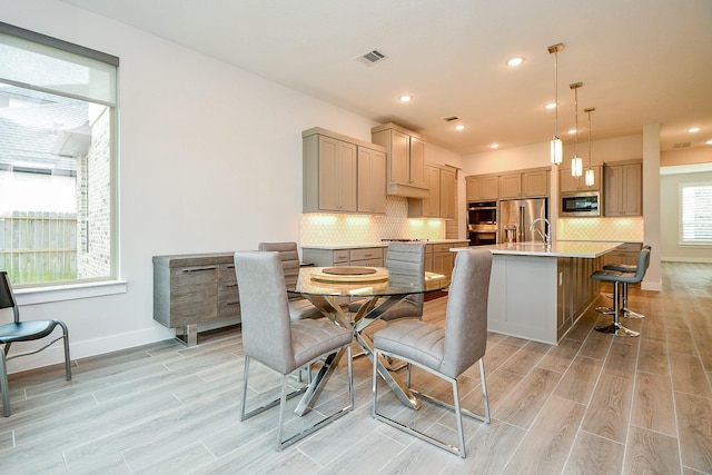 dining room featuring light wood-style flooring, visible vents, baseboards, and recessed lighting