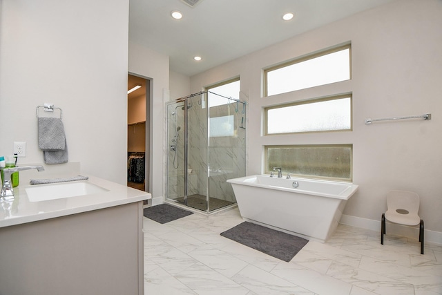 full bath with a freestanding bath, marble finish floor, a marble finish shower, and baseboards