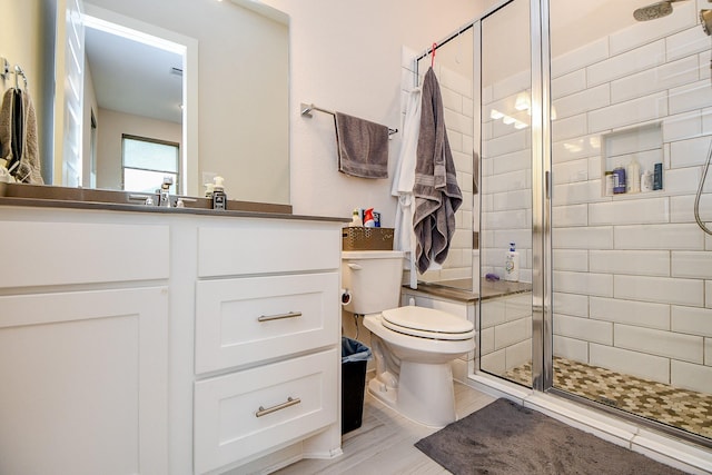 bathroom featuring a stall shower, vanity, and toilet