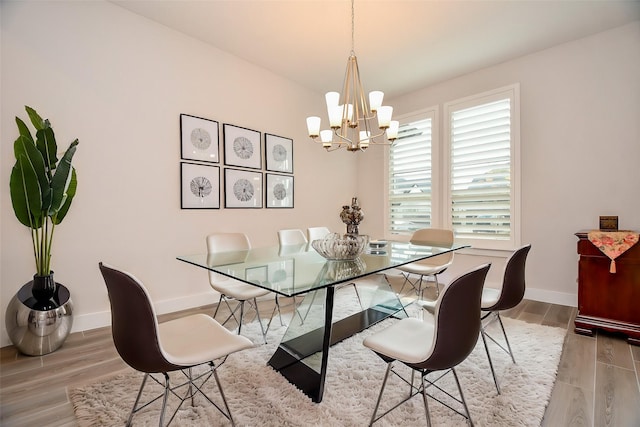 dining room with baseboards, a chandelier, and wood finished floors