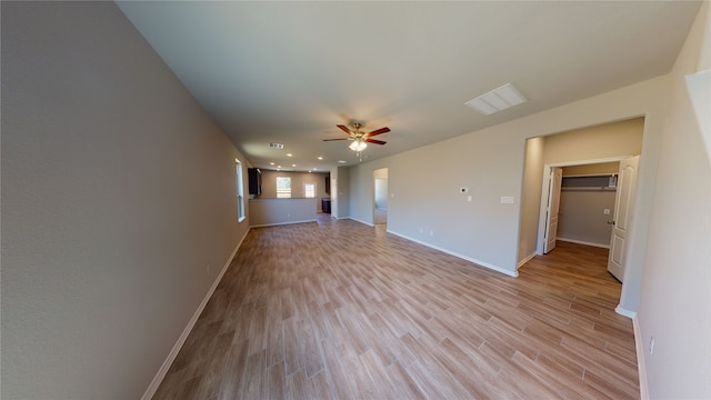 unfurnished living room featuring baseboards, ceiling fan, visible vents, and light wood-style floors