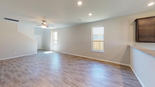 unfurnished room featuring ceiling fan, light wood-style flooring, and visible vents