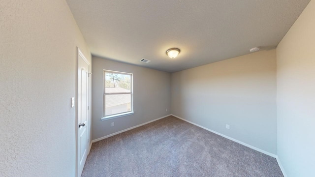 unfurnished room featuring visible vents, a textured ceiling, baseboards, and carpet flooring