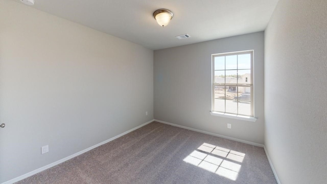 empty room featuring carpet, visible vents, and baseboards