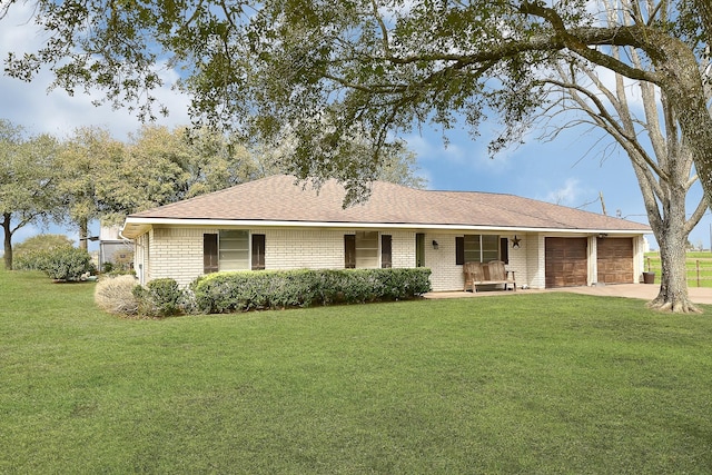 single story home featuring a garage, brick siding, driveway, roof with shingles, and a front yard