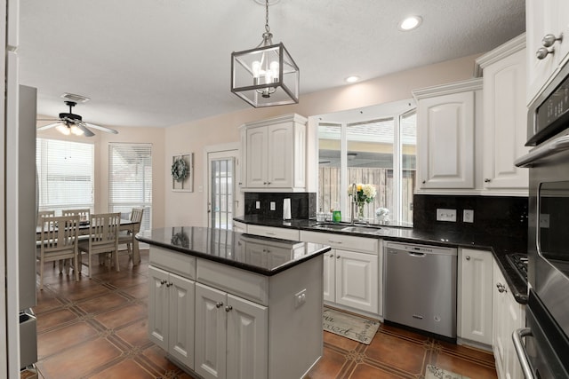 kitchen featuring a sink, white cabinetry, dishwasher, tasteful backsplash, and dark countertops