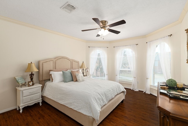 bedroom with baseboards, visible vents, dark wood finished floors, and ornamental molding